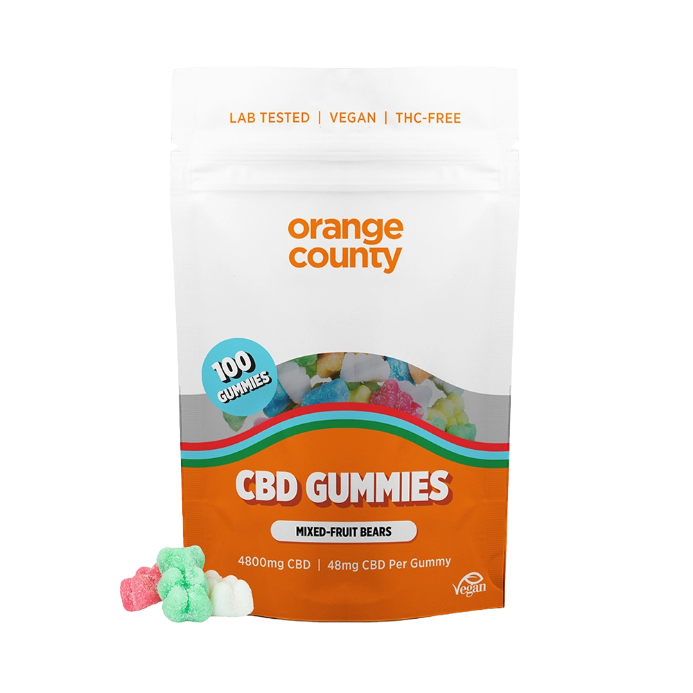 A stand-up pouch of Orange County CBD Gummies on a white background, with several small gummy candies placed in front of the package.
