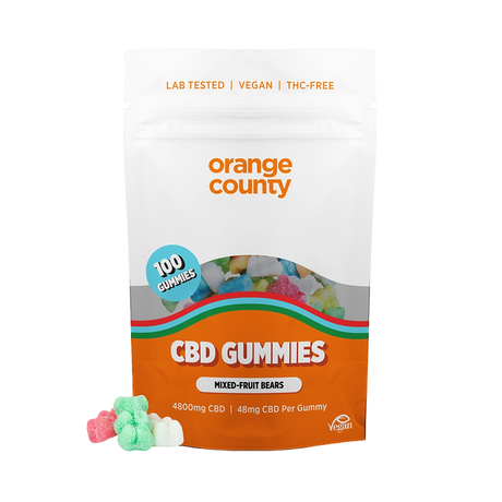 A stand-up pouch of Orange County CBD Gummies on a white background, with several small gummy candies placed in front of the package.