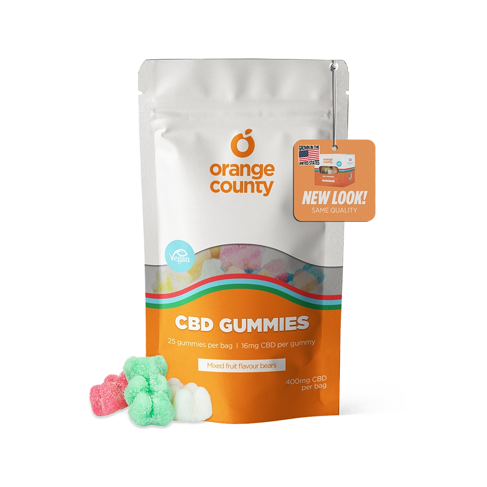 An orange and white stand-up pouch of Orange County CBD Gummies with a clear window showing multicolored gummies inside, plus three loose gummies in front on a white background.