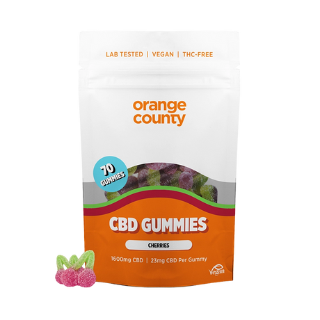 An orange and white stand-up pouch of Orange County CBD Gummies (Cherries) on a white background, with three cherry-shaped gummy candies displayed in the lower-left corner.
