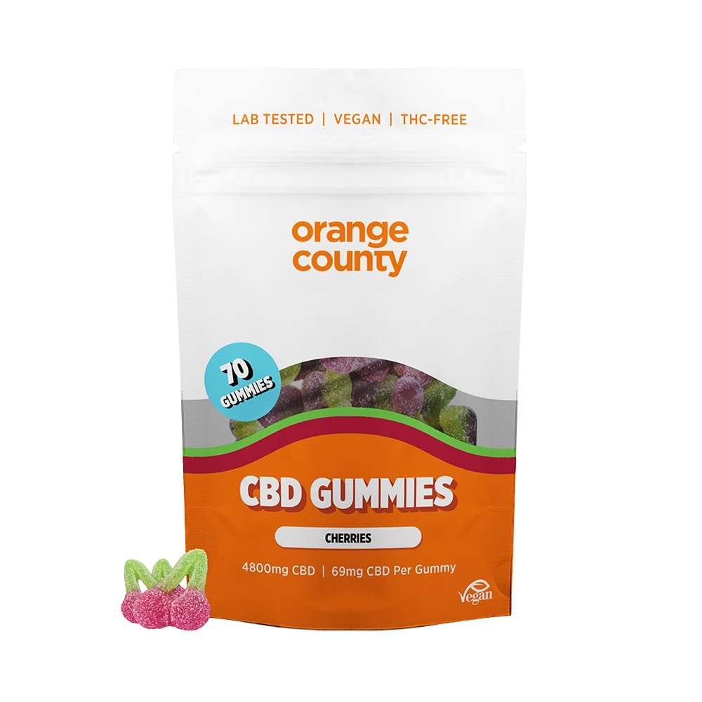 An orange and white stand-up pouch of Orange County CBD Gummies (Cherries) with a blue '70 Gummies' badge, shown on a white background with two cherry-shaped gummies in front.