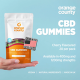 Orange County CBD Gummies packaging held by a hand with product details on a blue background