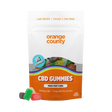 A stand-up pouch of Orange County CBD Gummies on a plain white background, with a few gummy candies placed in front. The package is mostly white and orange with a clear window showing multicolored gummies inside and a blue circular badge that says 95 gummies.