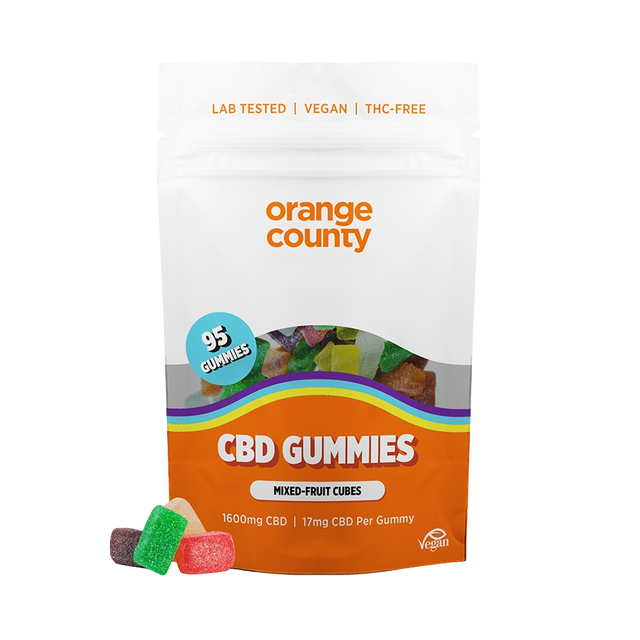 A stand-up pouch of Orange County CBD Gummies on a plain white background, with a few gummy candies placed in front. The package is mostly white and orange with a clear window showing multicolored gummies inside and a blue circular badge that says 95 gummies.