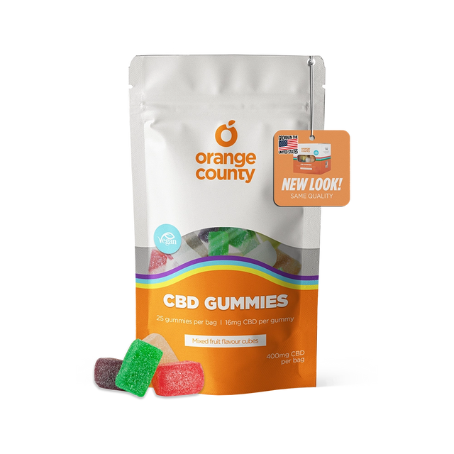 An orange and white stand-up pouch of Orange County CBD Gummies with several colorful gummy candies displayed in front on a white background.