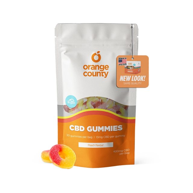 Orange County CBD Gummies pouch in peach flavor, shown on a white background with two gummy candies in front and a promotional hang tag.
