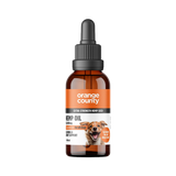 An amber glass dropper bottle of Orange County Hemp Oil for dogs, featuring a black dropper cap and a label with orange and white sections and a dog illustration, set against a plain white background.