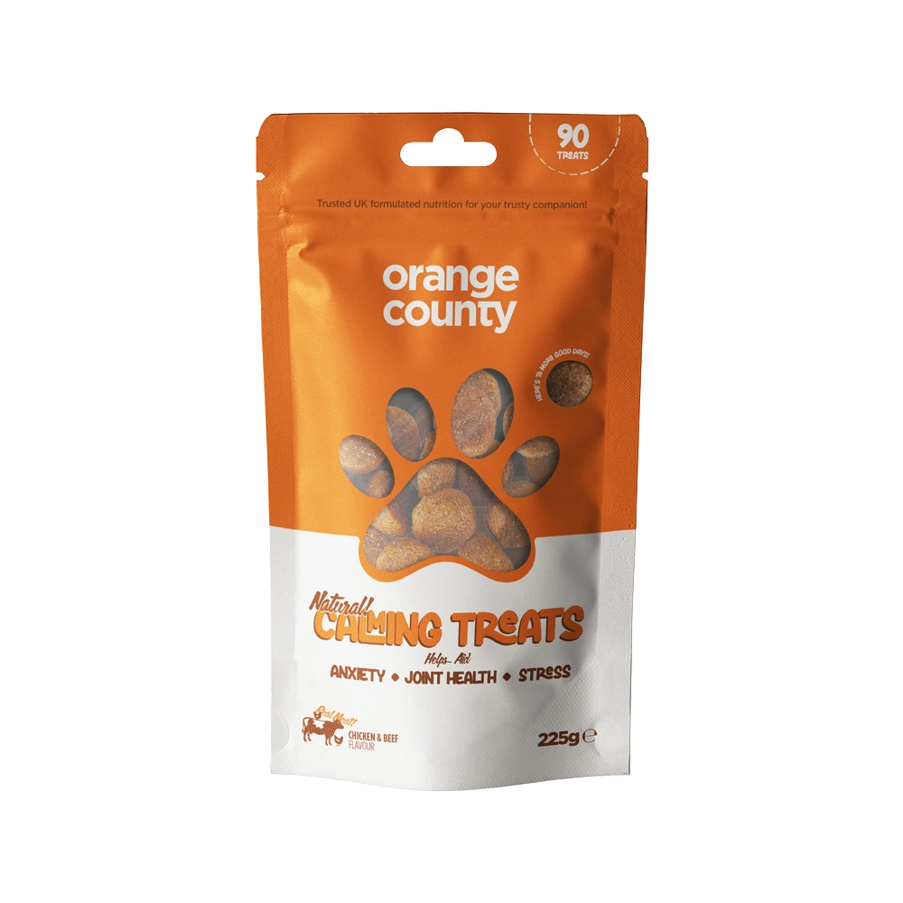A 225g stand-up pouch of Natural Calming Treats for dogs by Orange County, featuring an orange and white design with a paw print window showing the treats inside.