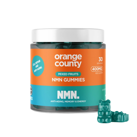 A jar of Orange County NMN Gummies for mixed fruits, featuring a bright orange and teal label with a white lid, shown alongside three green gummy bear candies on a white background.